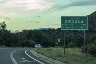 a green and white sign on the side of a road