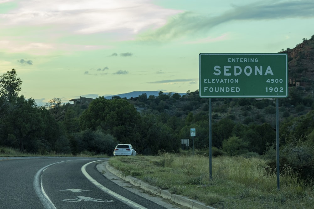 a green and white sign on the side of a road