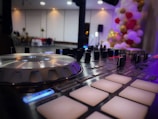 DJ mixing live at a wedding with golden lighting and elegant black decor.