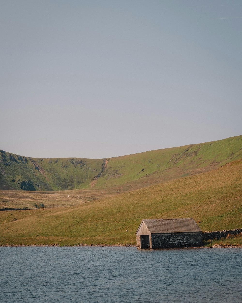 a small house sitting on the side of a lake