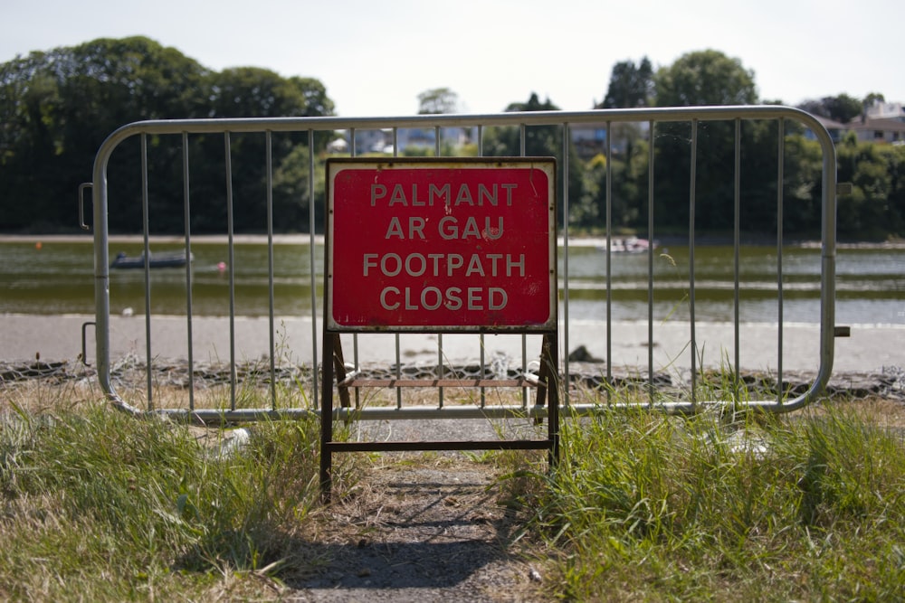 a red sign that is in the grass