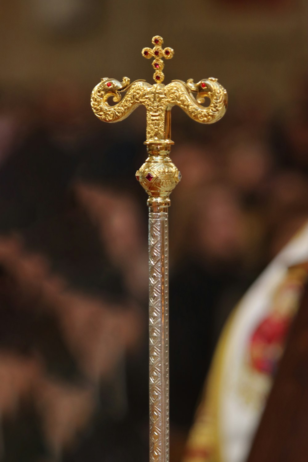 a golden cross on top of a metal pole