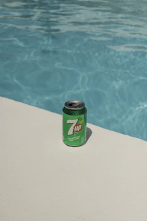 a can of 7up next to a swimming pool