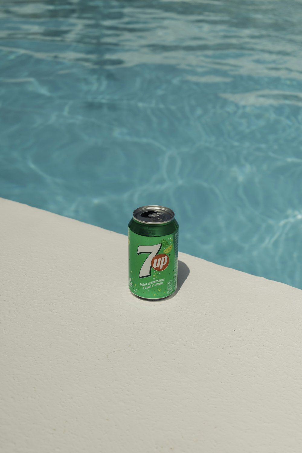 a can of 7up next to a swimming pool