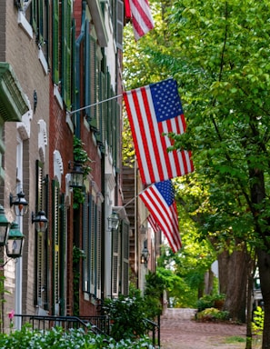 Historic brick townhouse with charming front porch and mature trees.