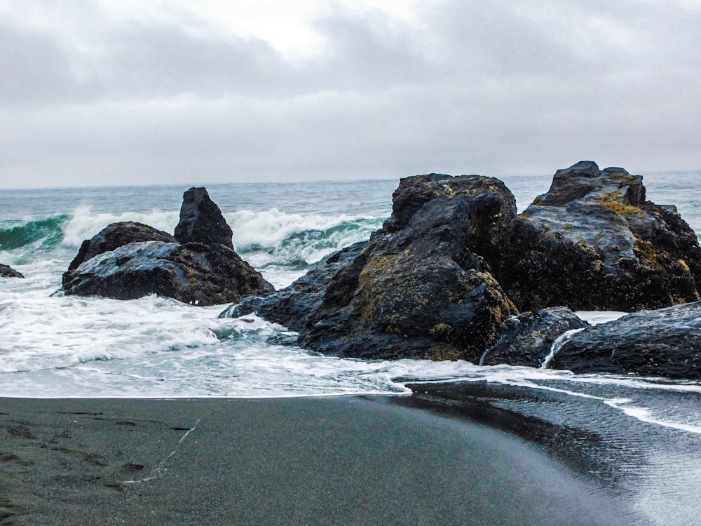 a couple of large rocks sitting on top of a beach