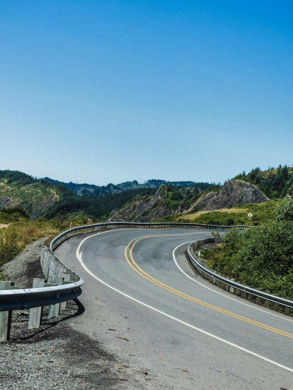 a curved road with a mountain in the background