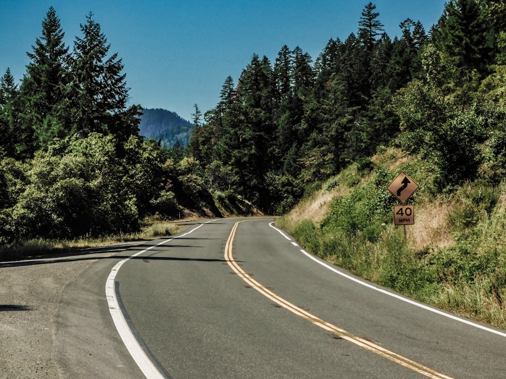 a curved road with a sign on the side of it