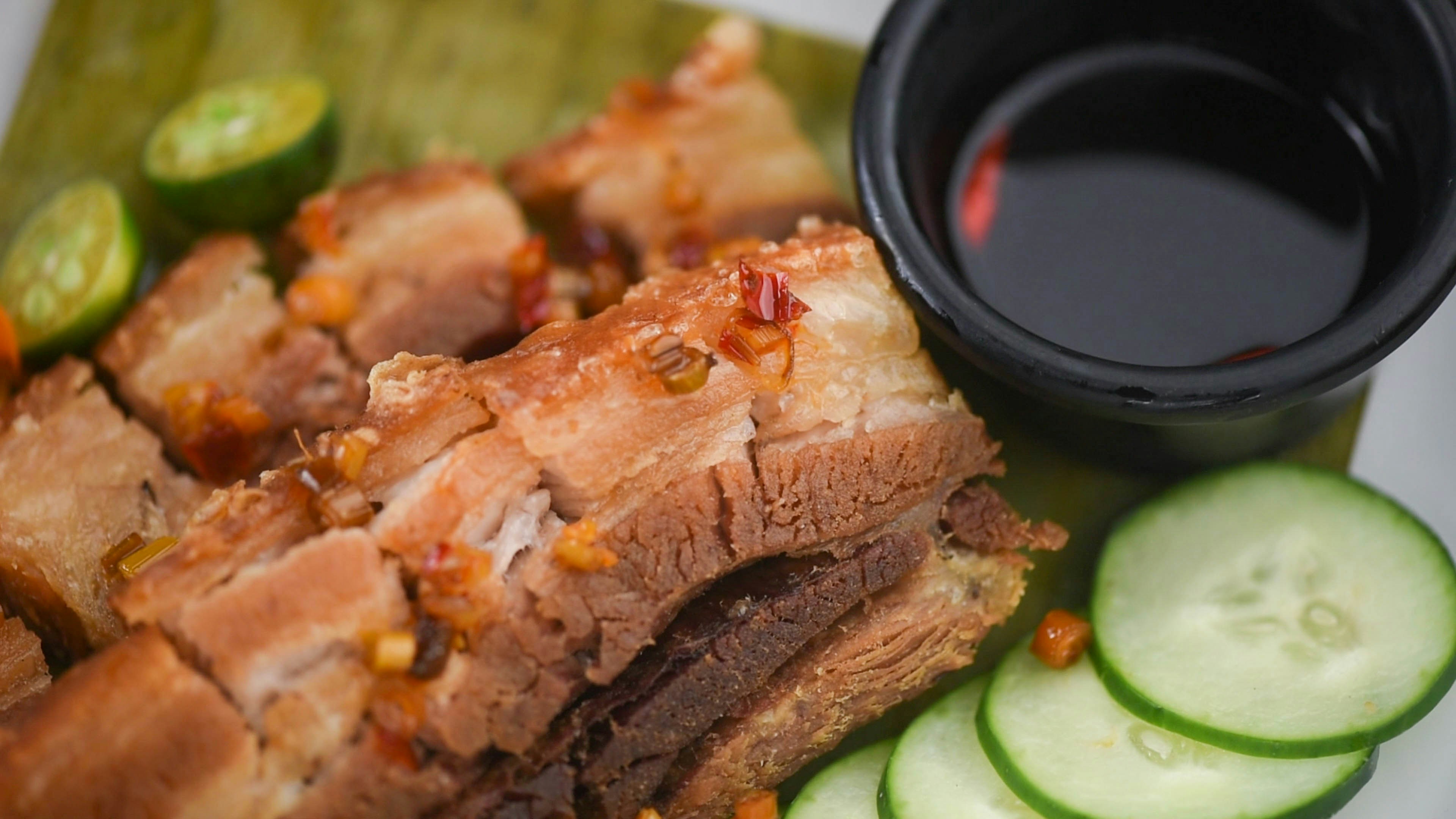 a close up of a plate of food with meat and cucumbers