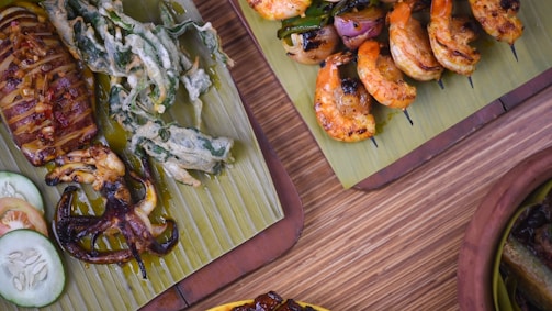 a table topped with plates of food covered in meat and veggies