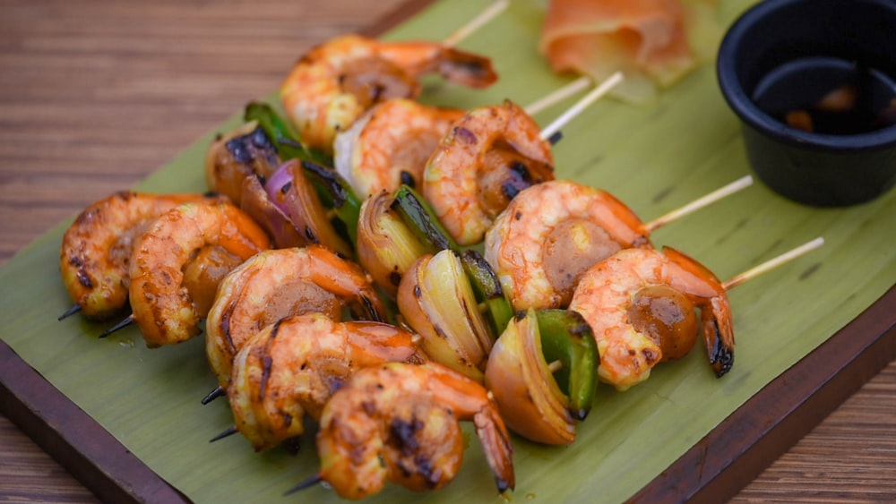 a green plate topped with shrimp and veggies