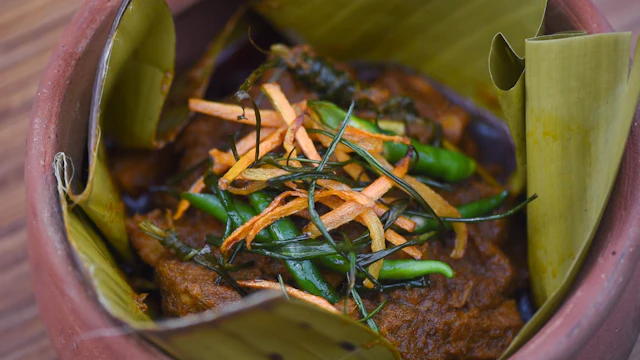 Rendang served in a leaf-lined clay pot