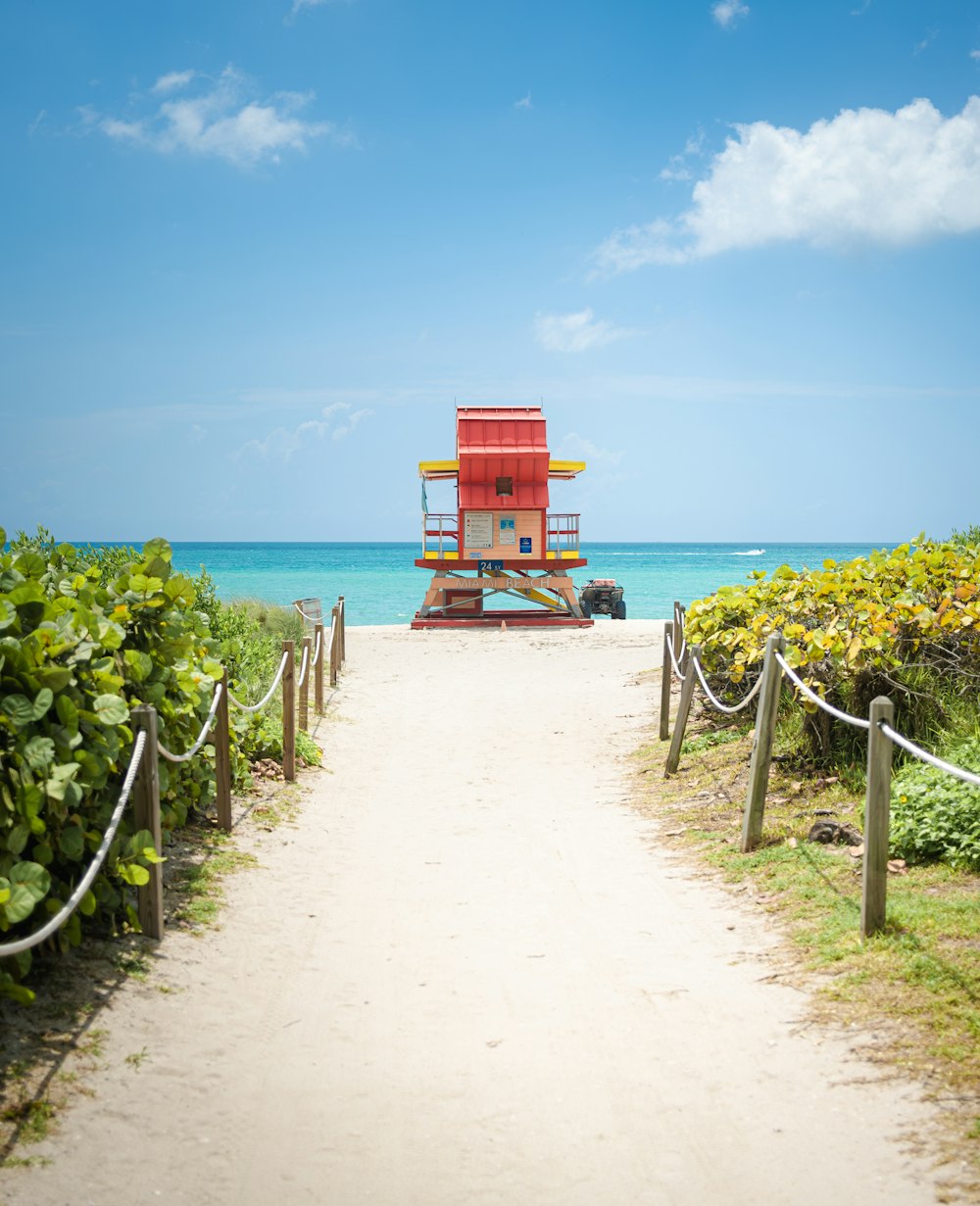 Una torre de salvavidas roja sentada en la cima de una playa de arena