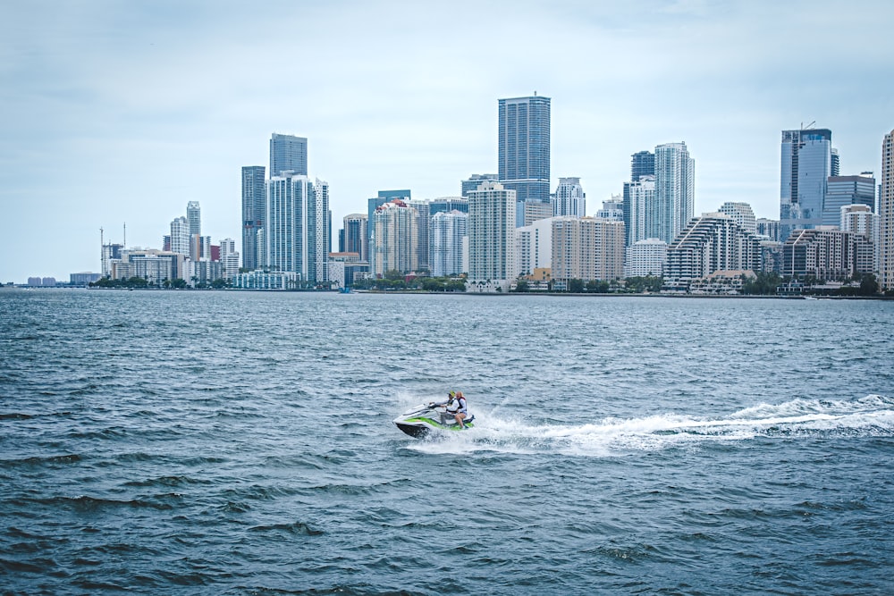 Una persona su una moto d'acqua di fronte allo skyline di una città