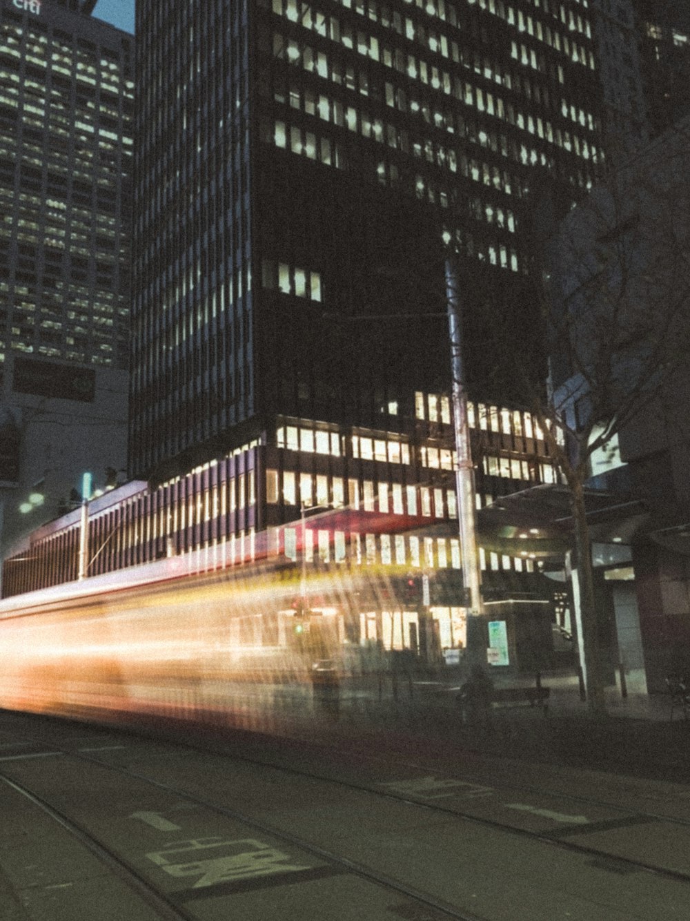 a long exposure photo of a train in the city at night