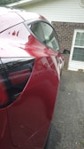 A shiny, freshly detailed car parked in a sunlit driveway.