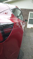 Side view of a shiny, waxed vehicle parked on a clean driveway.