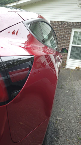 Side view of a shiny, waxed vehicle parked on a clean driveway.