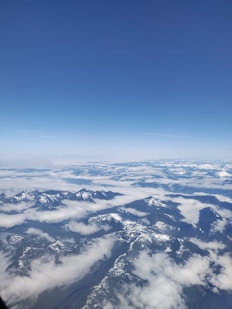 A panoramic view of snow-capped mountains against a blue sky.