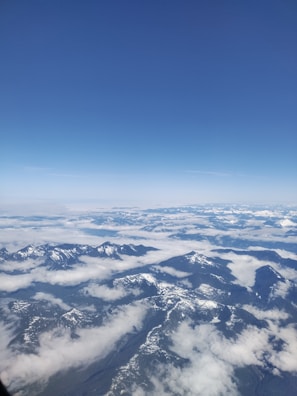 A panoramic view of snow-capped Himalayan peaks under a clear blue sky.
