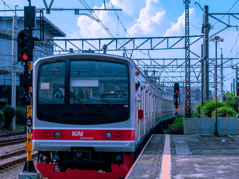 a red and white train traveling down train tracks