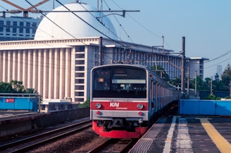 a red and white train traveling down train tracks