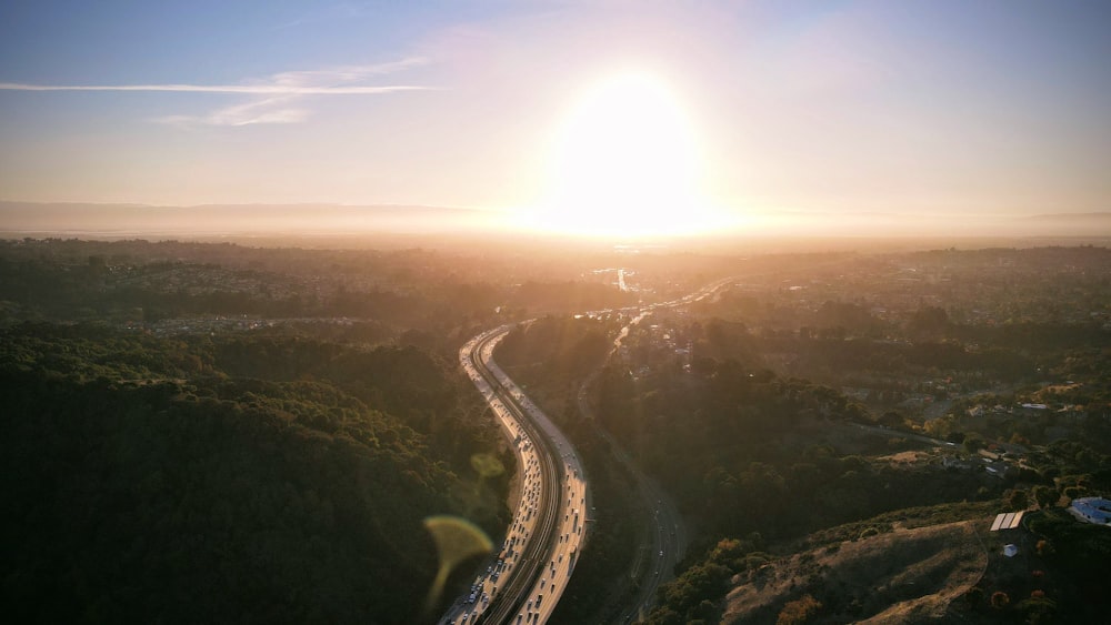 the sun is setting over a winding road