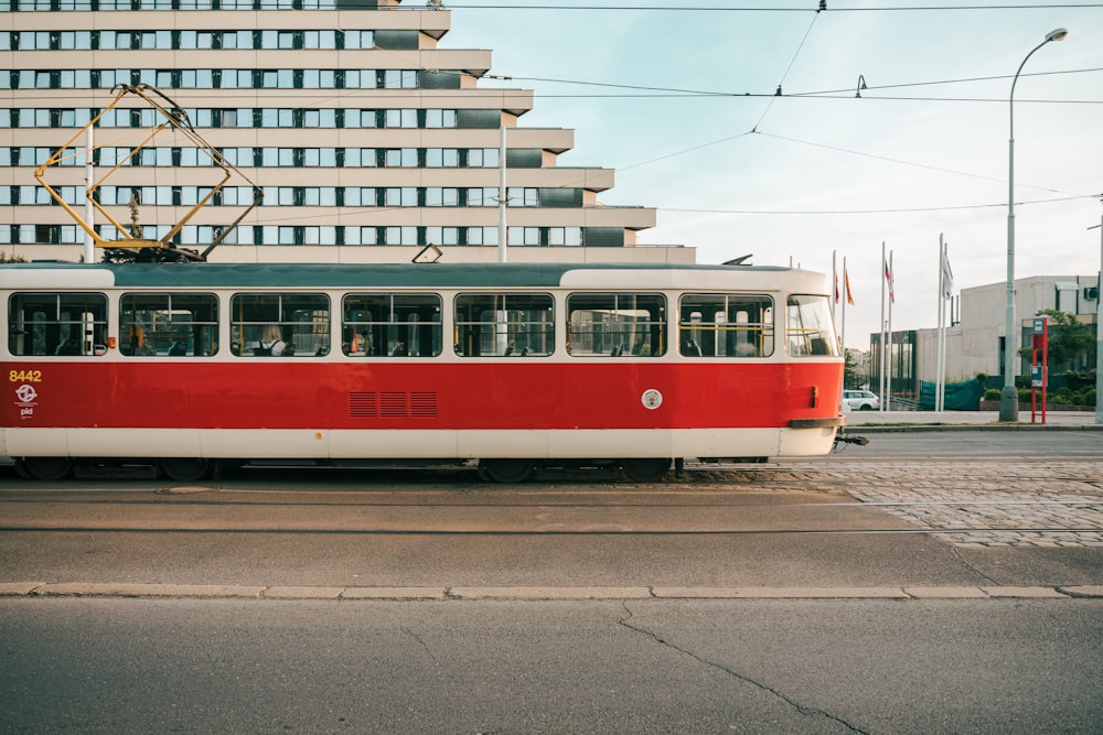 a red and white trolley on a city street