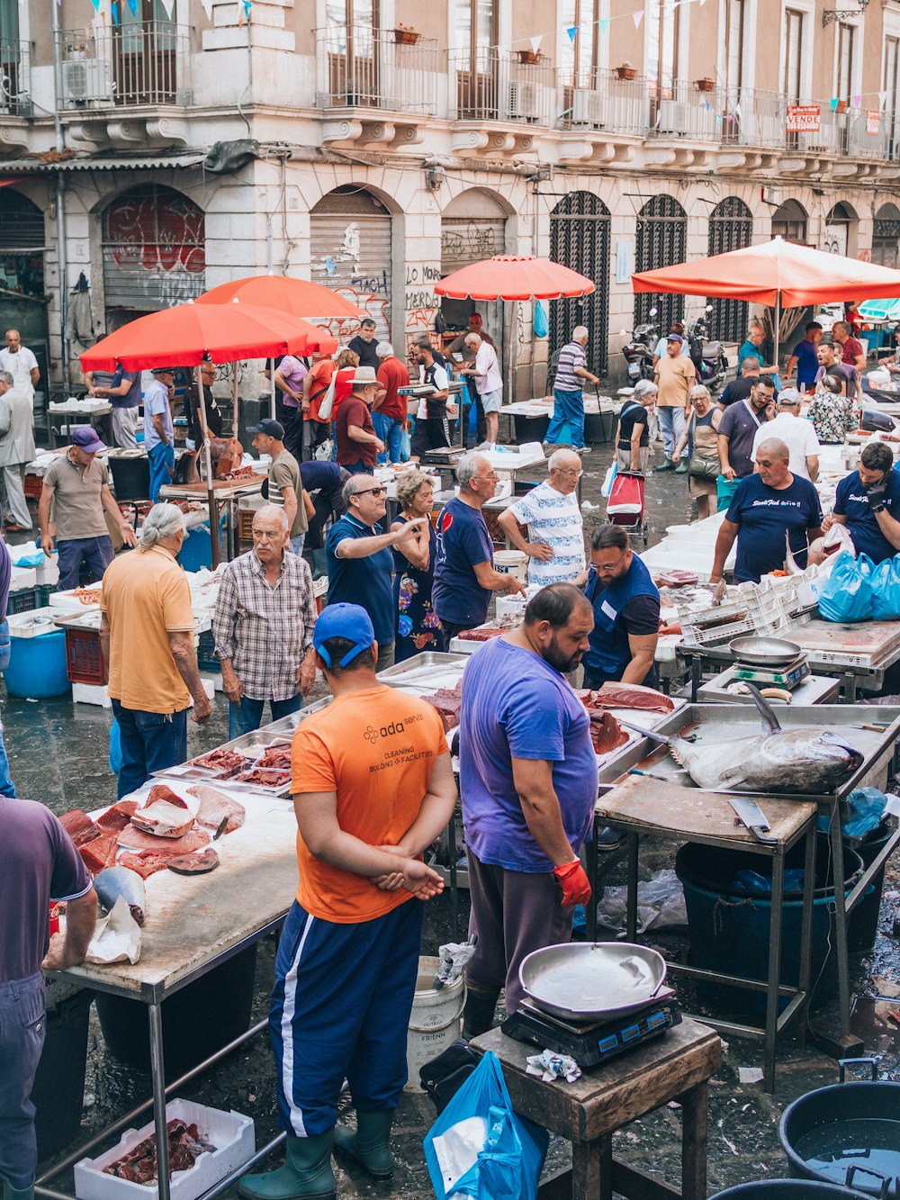 a group of people standing around tables with food on them