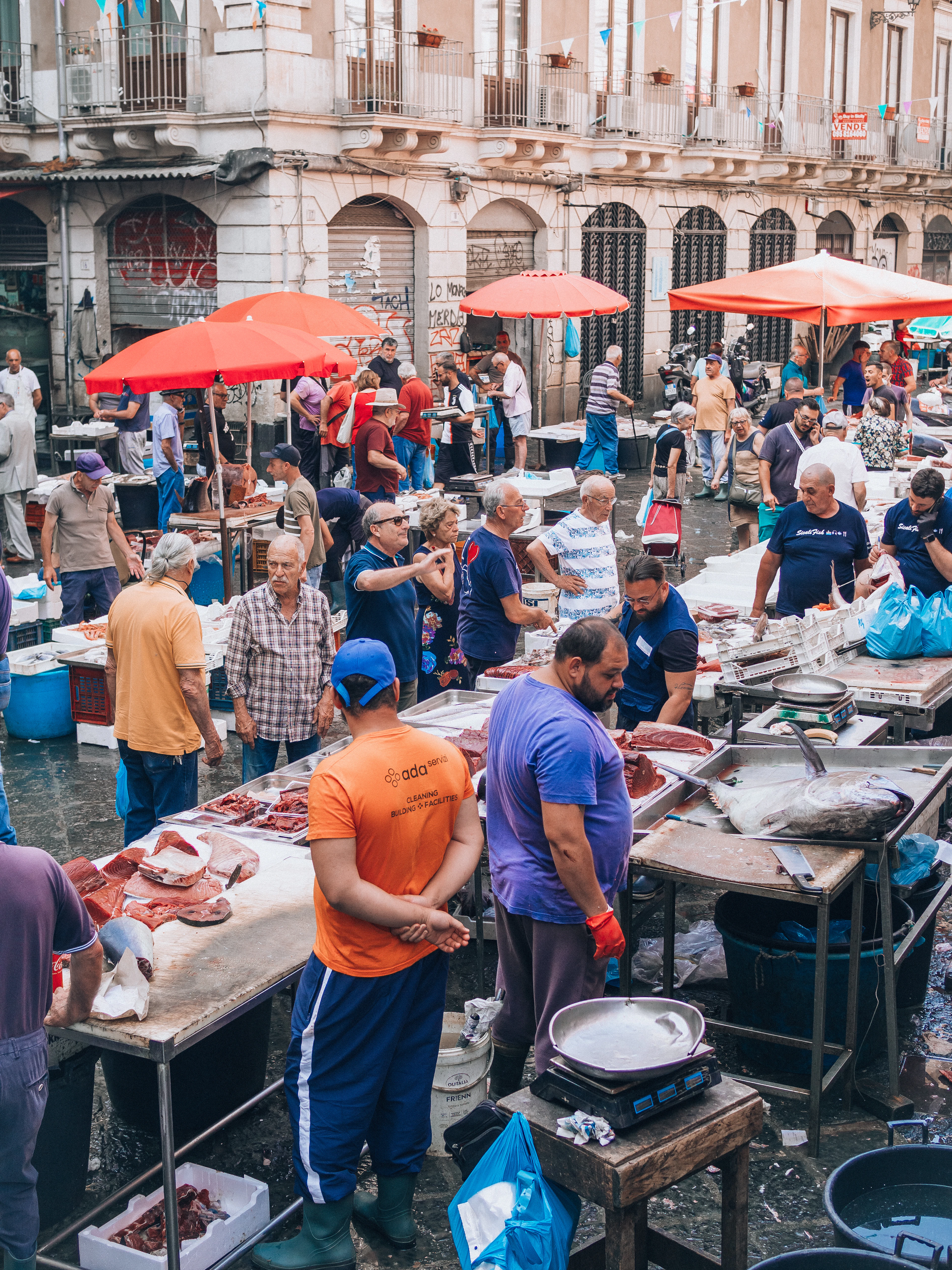 Vendors sell fresh fish and seafood at Catania's crowded outdoor Pescheria market.