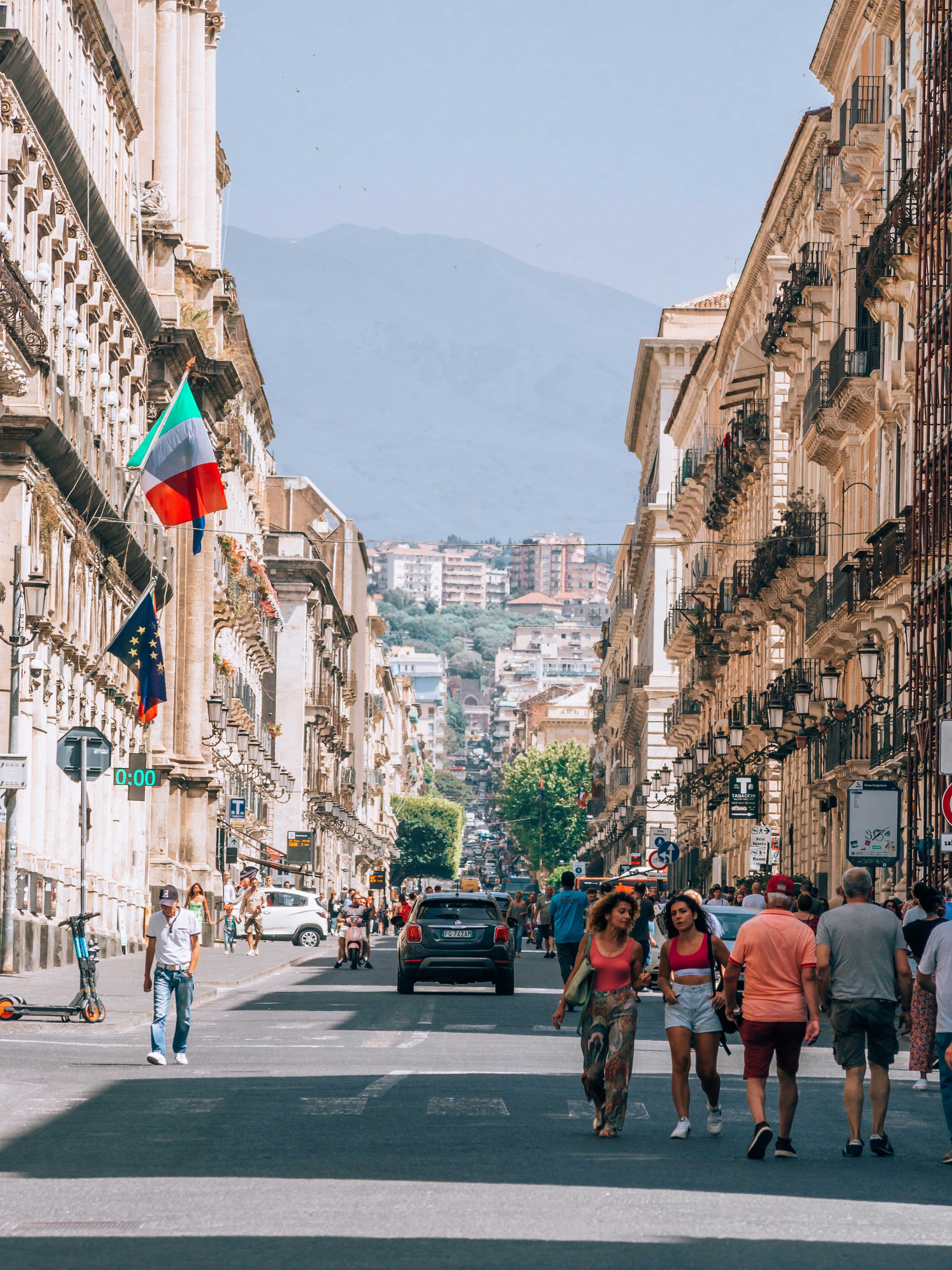Un groupe de personnes marchant dans une rue à côté de grands immeubles