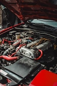 the engine of a red car with its hood open