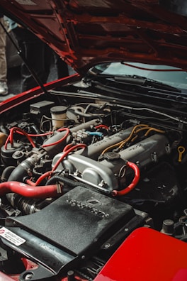 the engine of a red car with its hood open