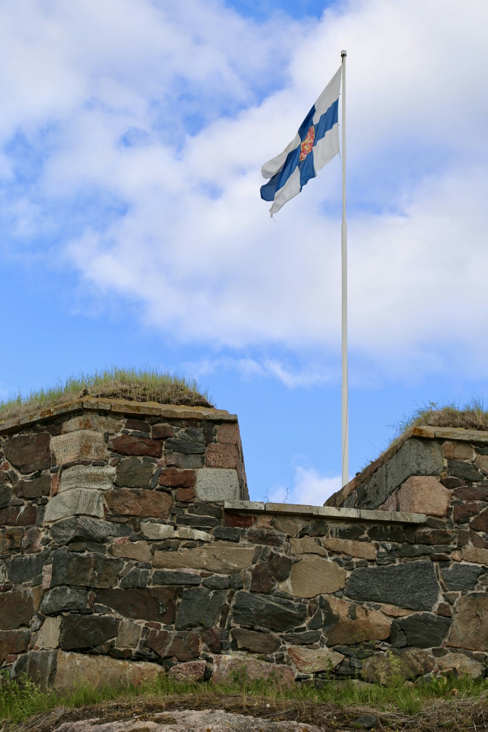 a stone wall with a flag on top of it