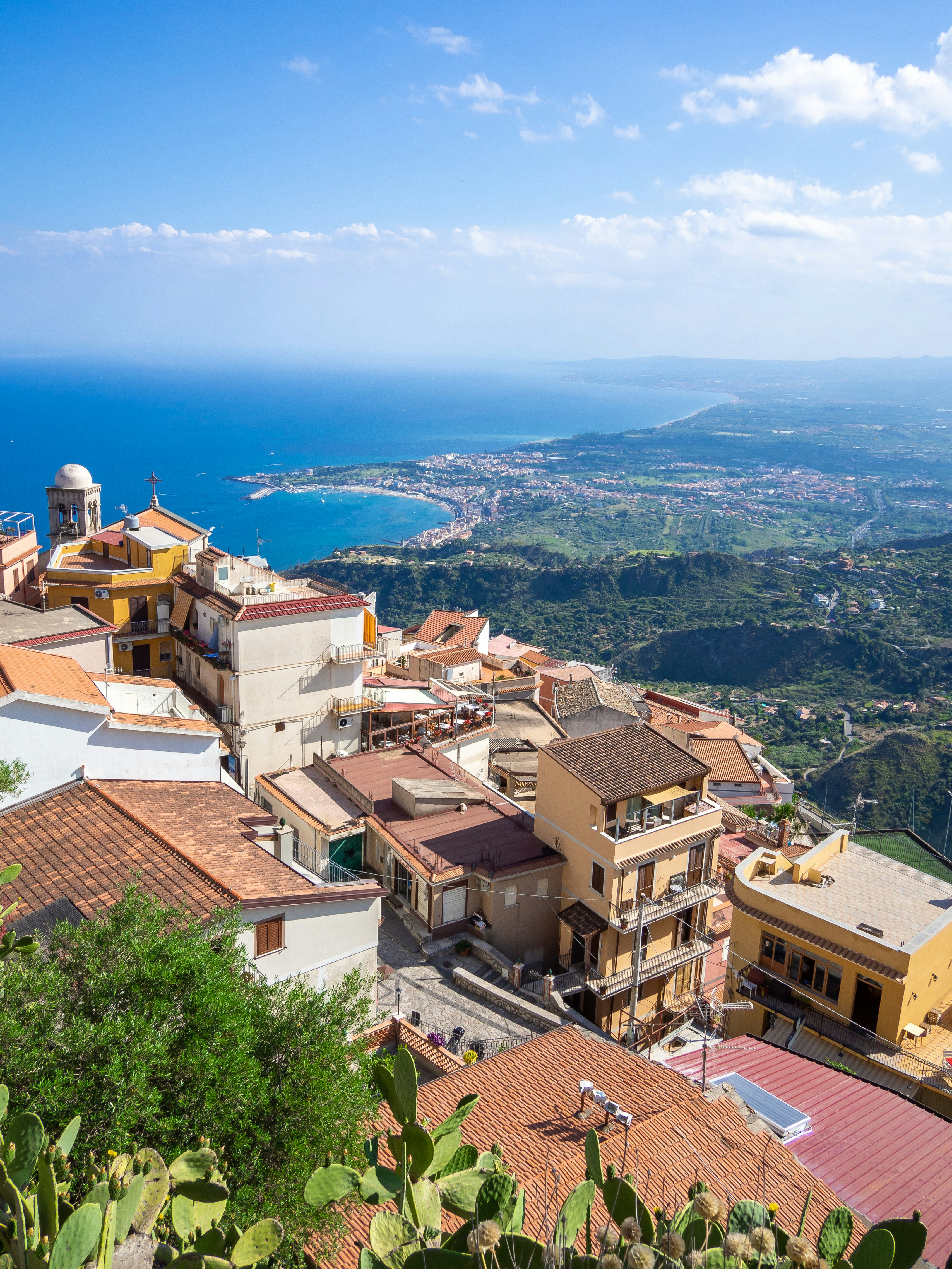 Italian coastal villa with terracotta rooftop, bright daylight, Amalfi sea in background, lemon trees