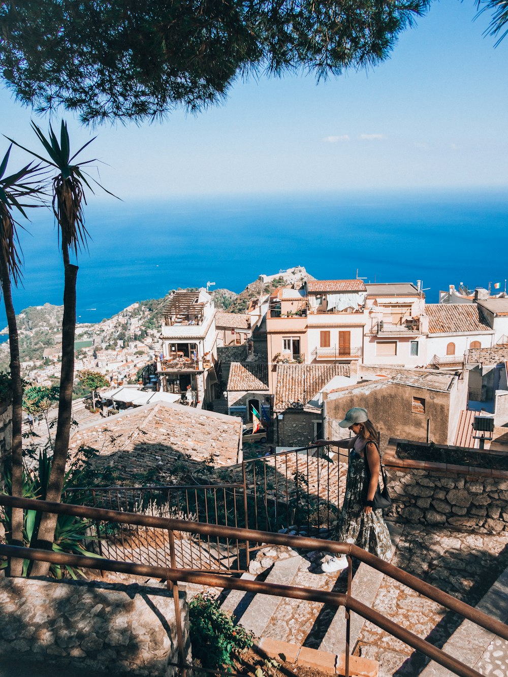 a man walking up a set of stairs next to the ocean