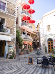 a group of red umbrellas hanging from the side of a building