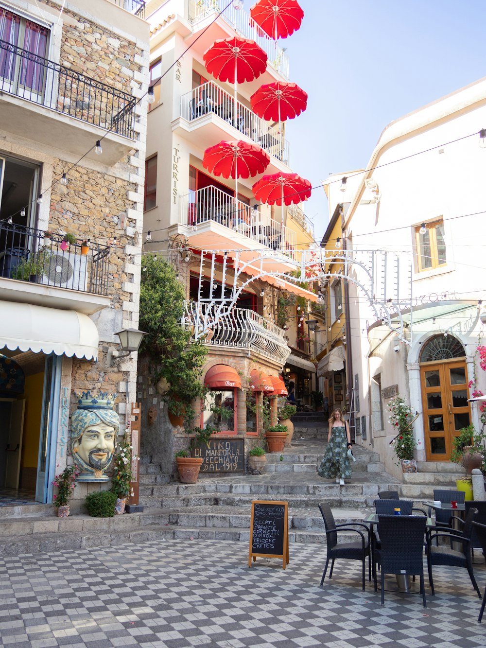 a group of red umbrellas hanging from the side of a building