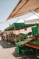 A colorful expo stand showcasing fresh local produce with vibrant signage and smiling vendors.