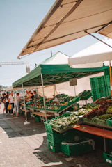 Community members gathered around a farm stand sharing laughter and fresh produce.