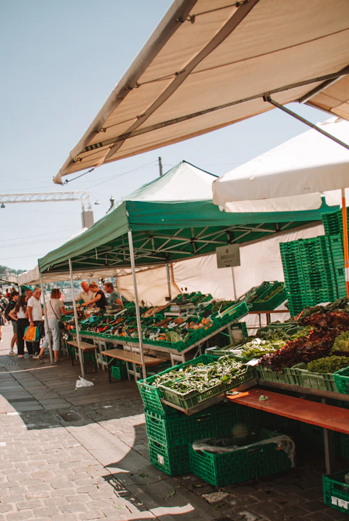 A colorful expo stand showcasing fresh local produce with vibrant signage and smiling vendors.