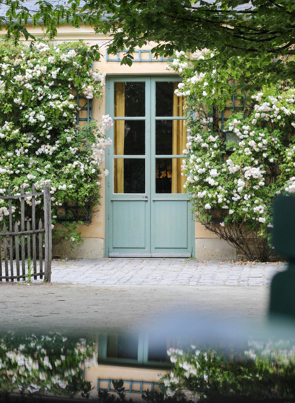 una casa con una puerta de entrada azul y un banco frente a ella