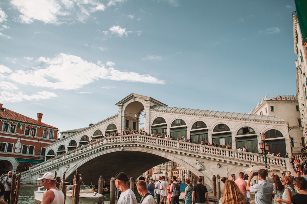 a group of people standing on the side of a bridge