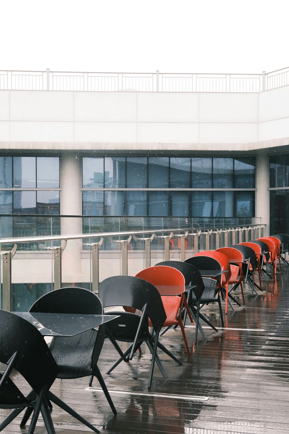 a row of black and orange chairs sitting in front of a building