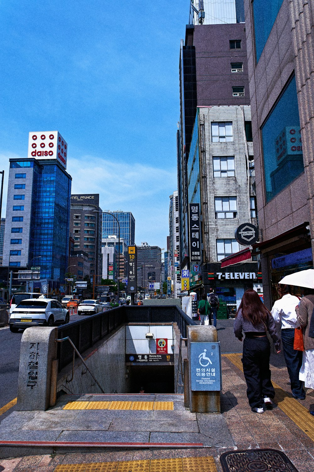 a group of people walking down a street next to tall buildings