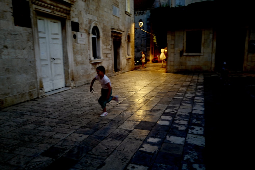 a young boy is playing with a frisbee at night