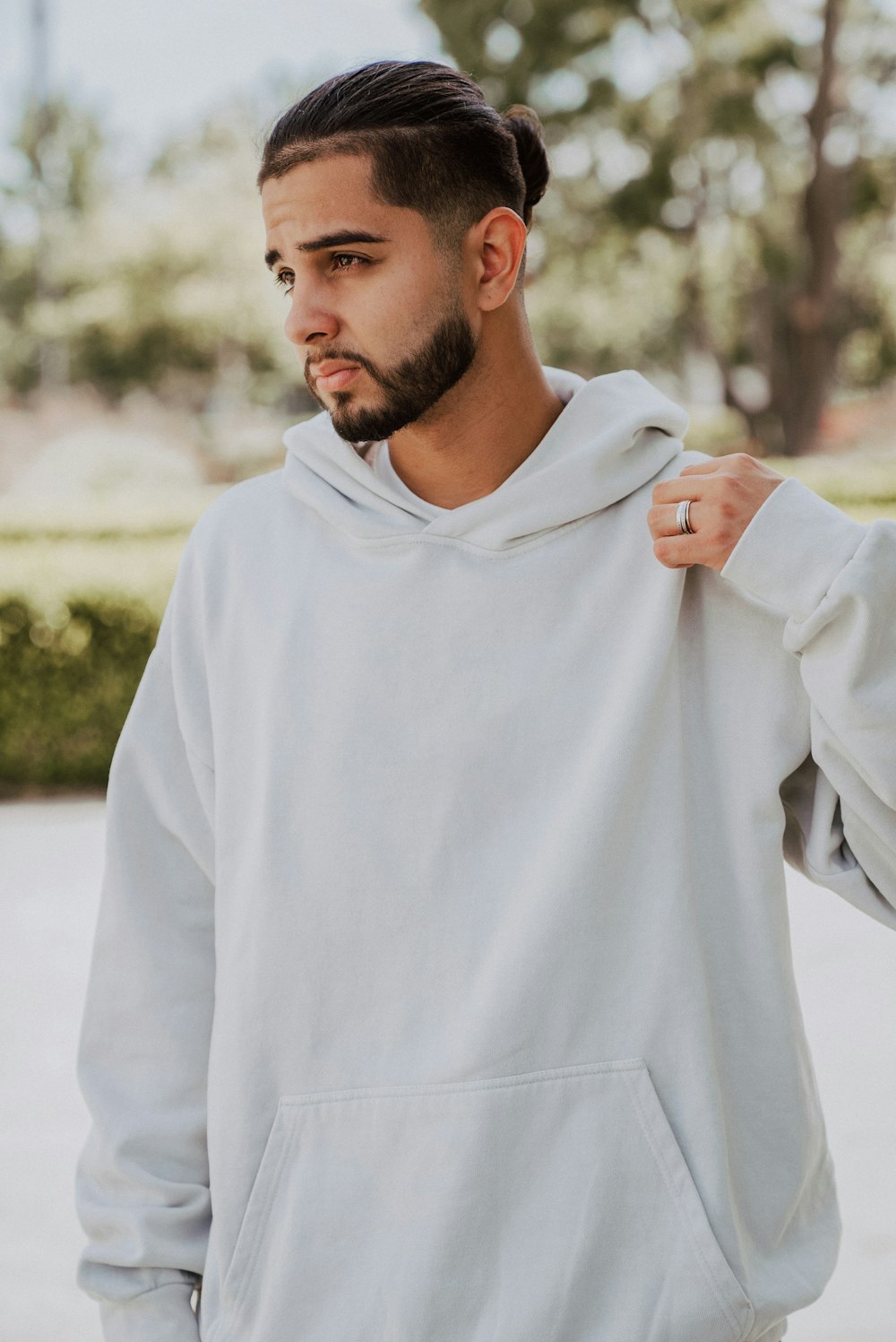 a man with a beard wearing a white hoodie