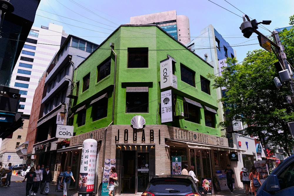 Un edificio verde all'angolo di una strada della città