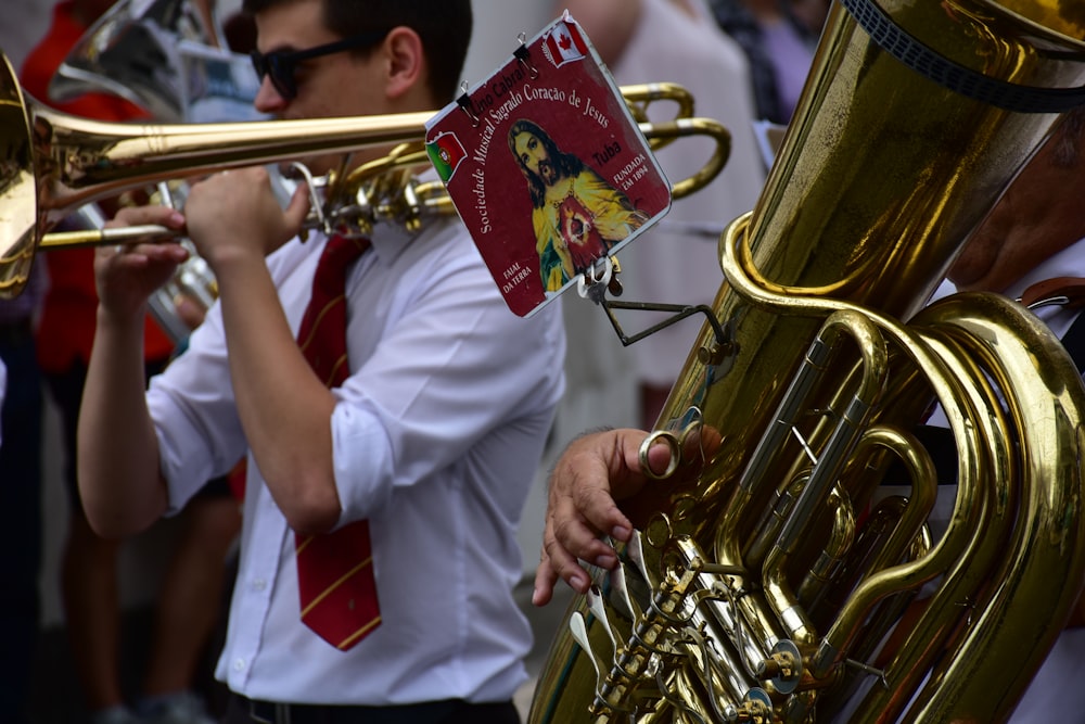 a man in a white shirt and tie playing a trumpet