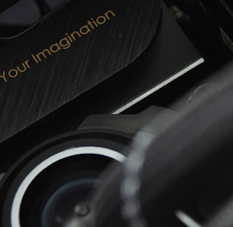 A close-up view of a mechanical or technological component with a sleek design and metallic textures is displayed. The phrase 'Power Up Your Imagination' is etched on the surface, suggesting encouragement or inspiration, possibly for creative or innovative activities.